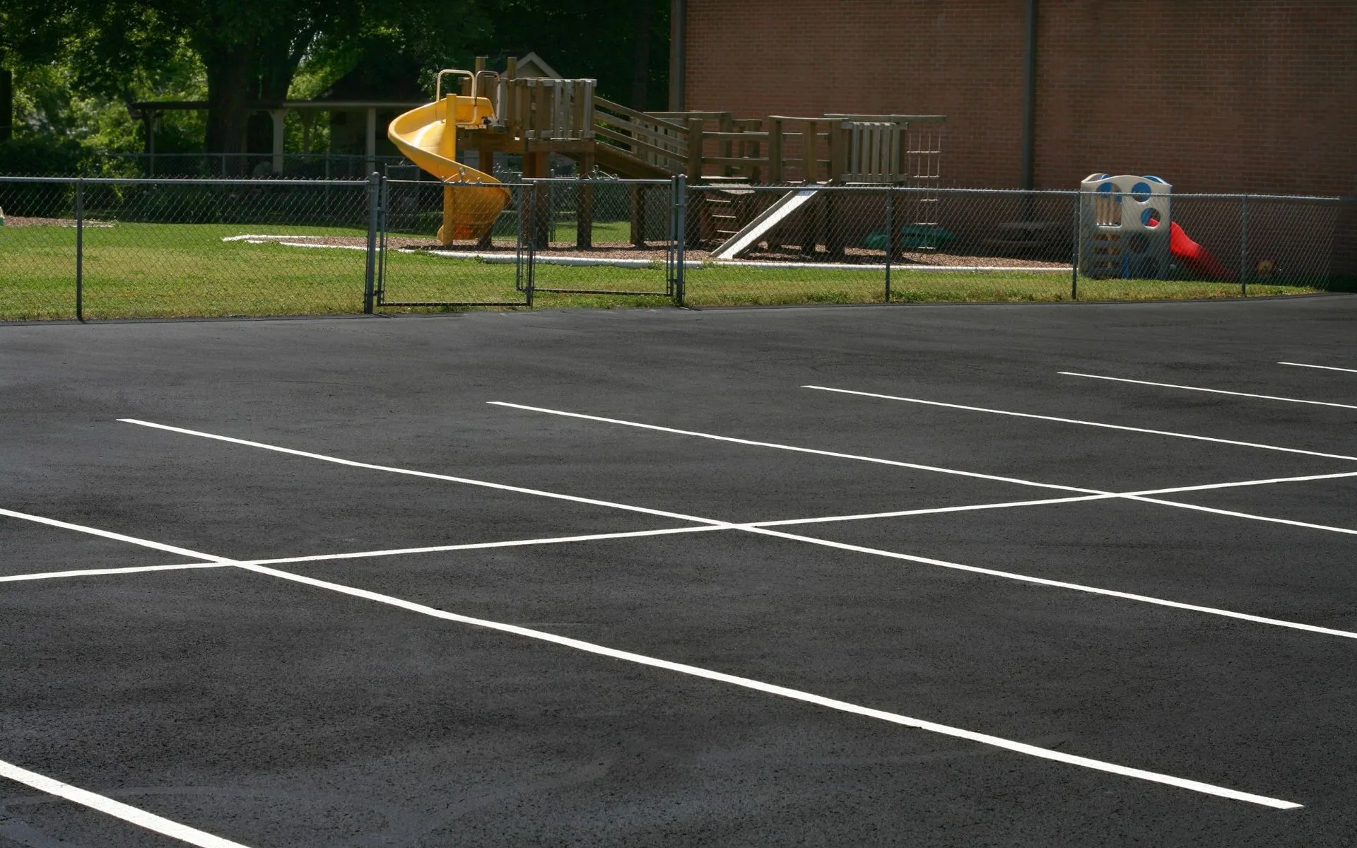 Asphalt parking lot with seal coat, stripes, and markings