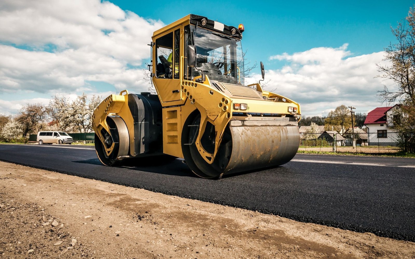 professional asphalt contractor compacting the newly laid asphalt with rollers